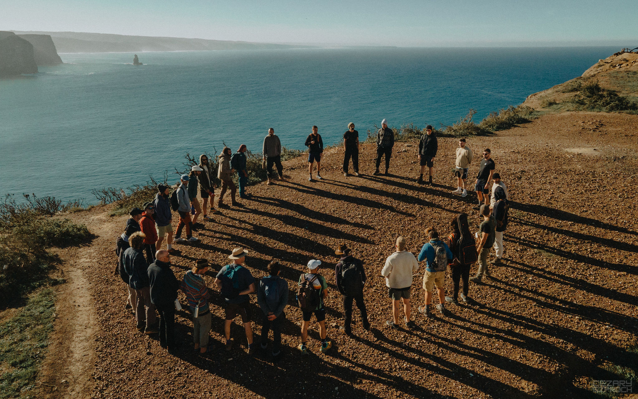 Men in circle on the cliff above the Atlantic at a Men's Academy intensive